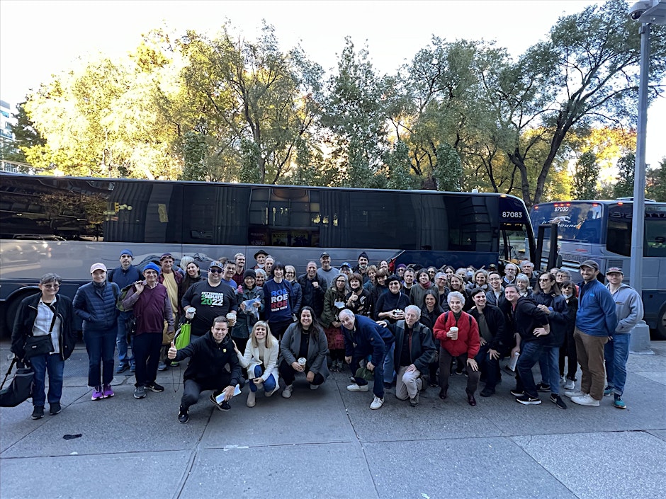 Volunteers standing next to a bus